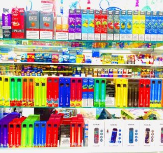 A display featuring various brands of cigarettes and tobacco products arranged on a retail shelf.